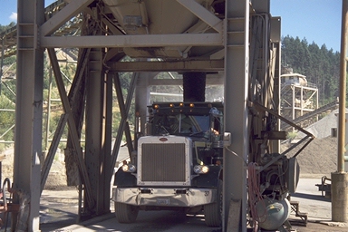 Truck loading under conveyor at material plant for site development
