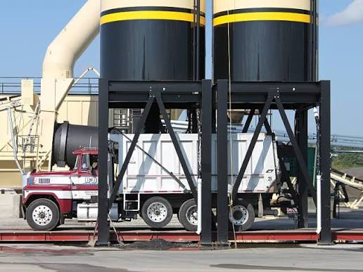Truck under material silos for demolition debris hauling