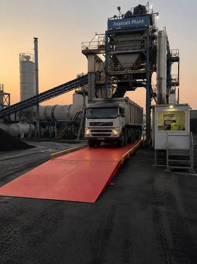 Truck at asphalt plant weigh station for public works materials