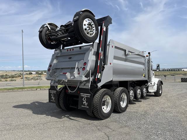 Super dump truck with folding trailer axle for excavation hauling